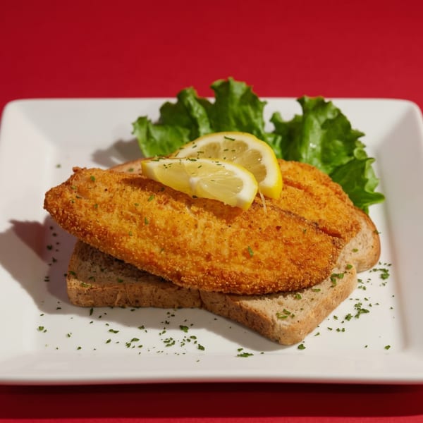 Golden-fried fish fillets on toast with lemon slices and lettuce, on a white plate.